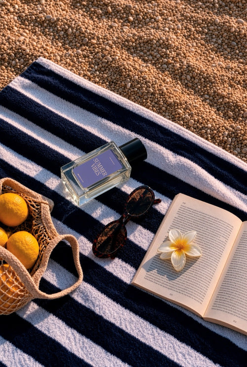 Perfume bottle mockup PSD on a striped beach towel with sunglasses, a frangipani flower, and lemons