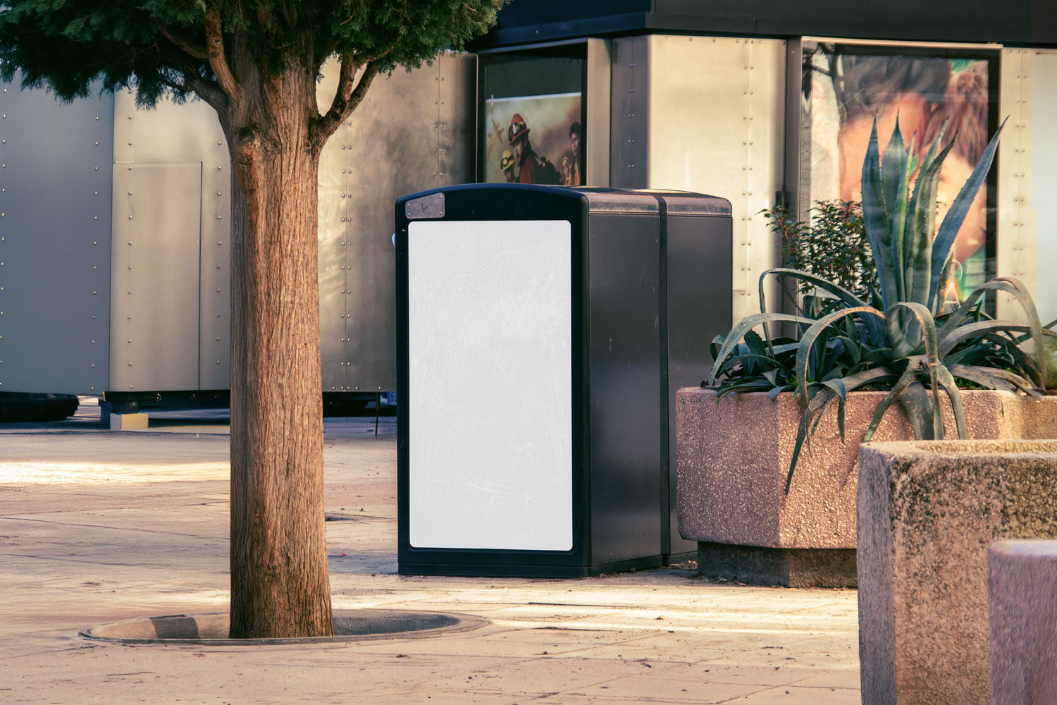 Real photo trash bin billboard mockup PSD in city plaza with natural light and plants