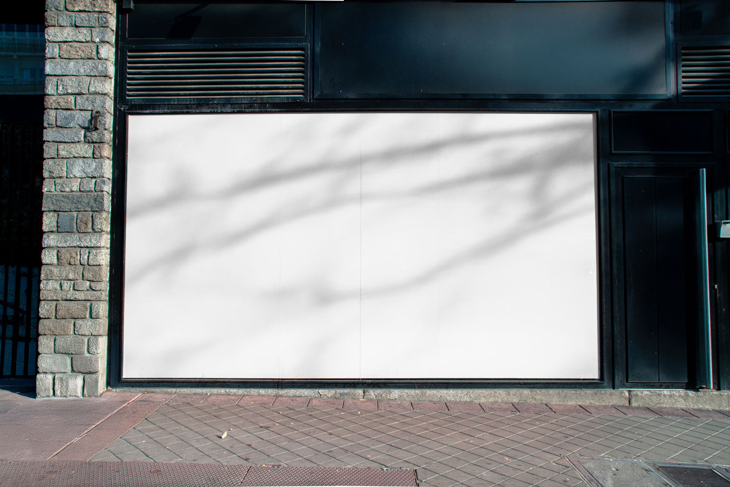 Real photo storefront poster mockup on shop façade with natural shadows
