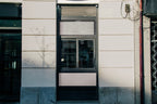 Real photo storefront poster mockup PSD on shop window with natural reflections and shadows