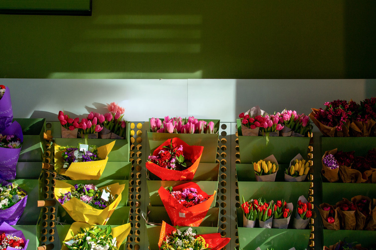 Real photo flower shop billboard/banner mockup behind bouquets with natural light and shadows