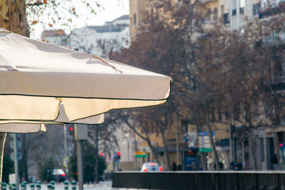 Real photo patio umbrella mockup PSD with logo area on fabric under natural light, city background
