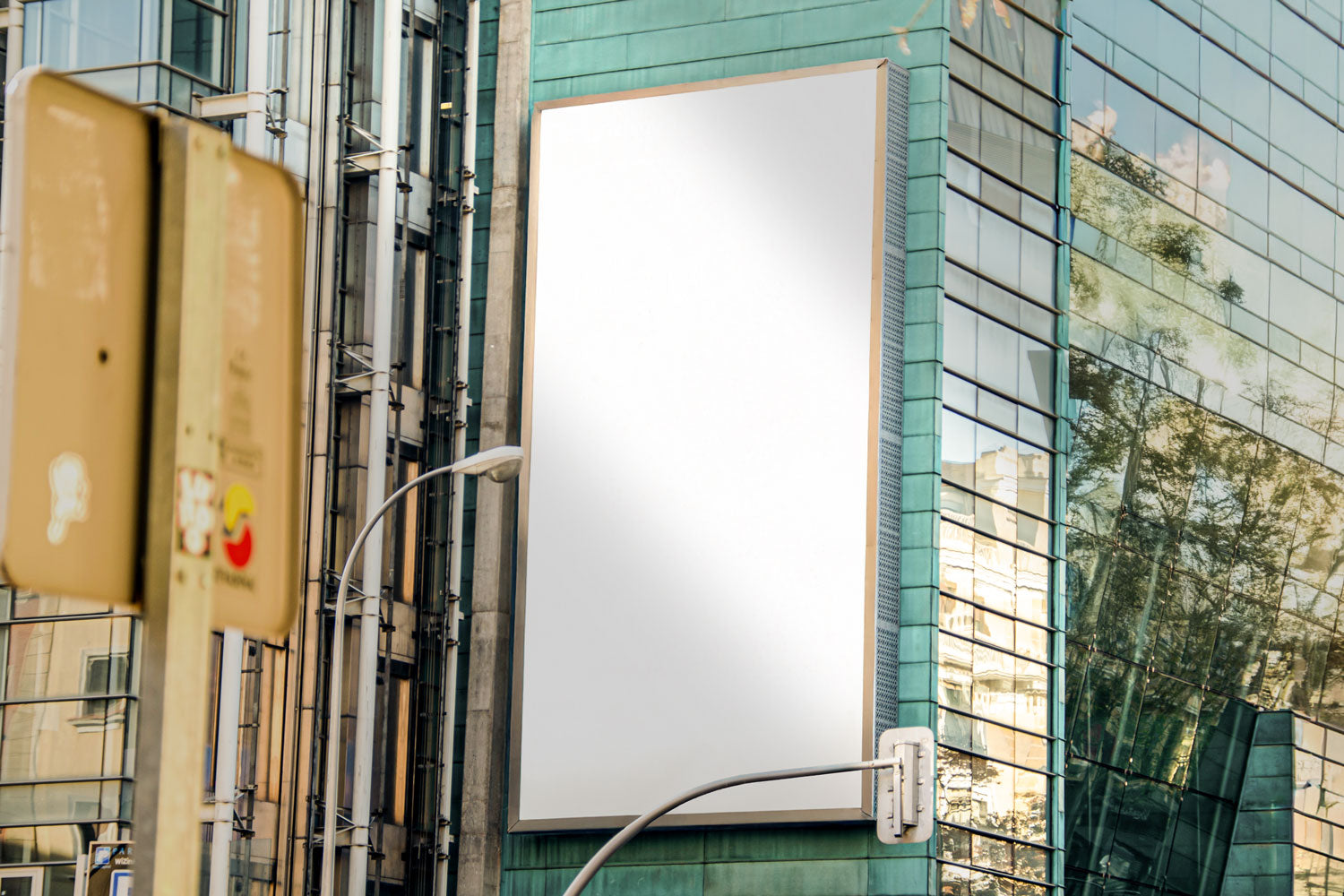 Real photo billboard mockup PSD on glass building with city reflections
