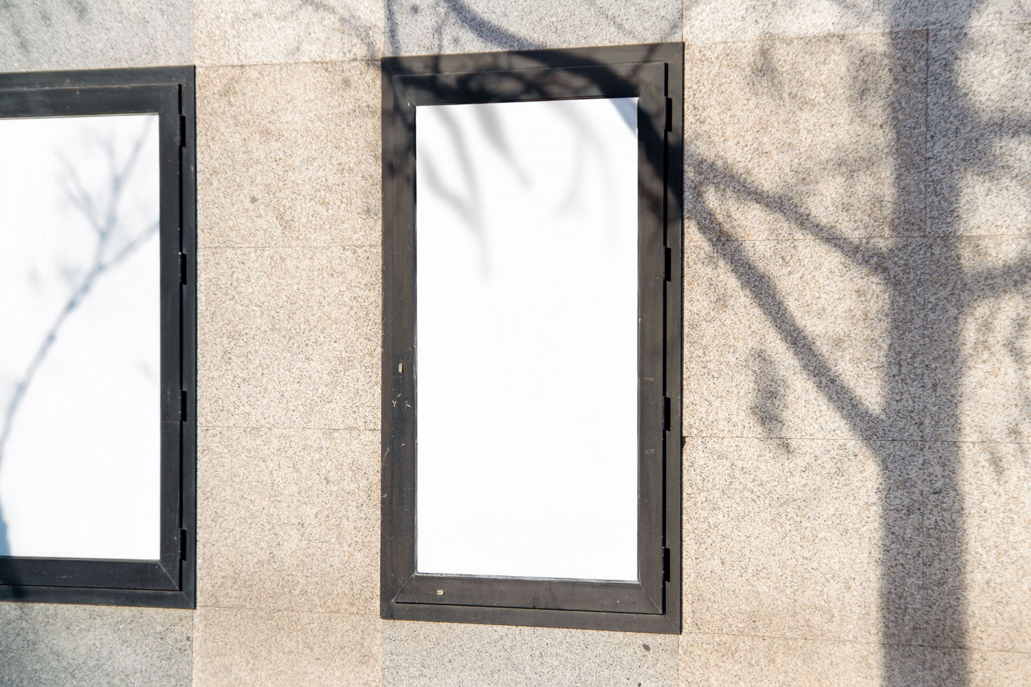 Real photo street poster frame mockup on stone wall with natural shadows