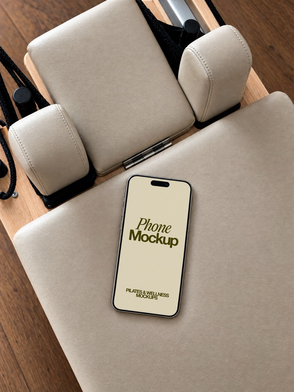 Phone screen mockup lying on the beige leather carriage of a pilates reformer, seen from above. iPhone mockup for fitness apps and studio social media. Phone mockup, iPhone mockup, app mockup, screen mockup, pilates mockup, wellness mockup, high quality mockup, PSD file.