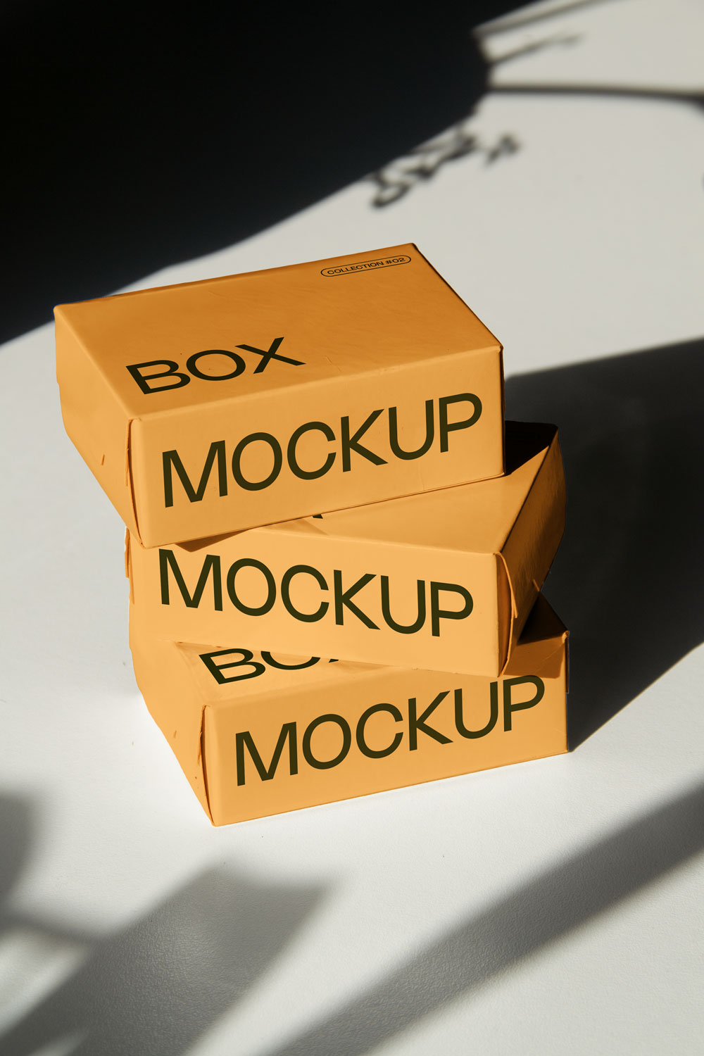 box packaging mockup PSD with three stacked paper boxes on sunlit desk and plant shadows