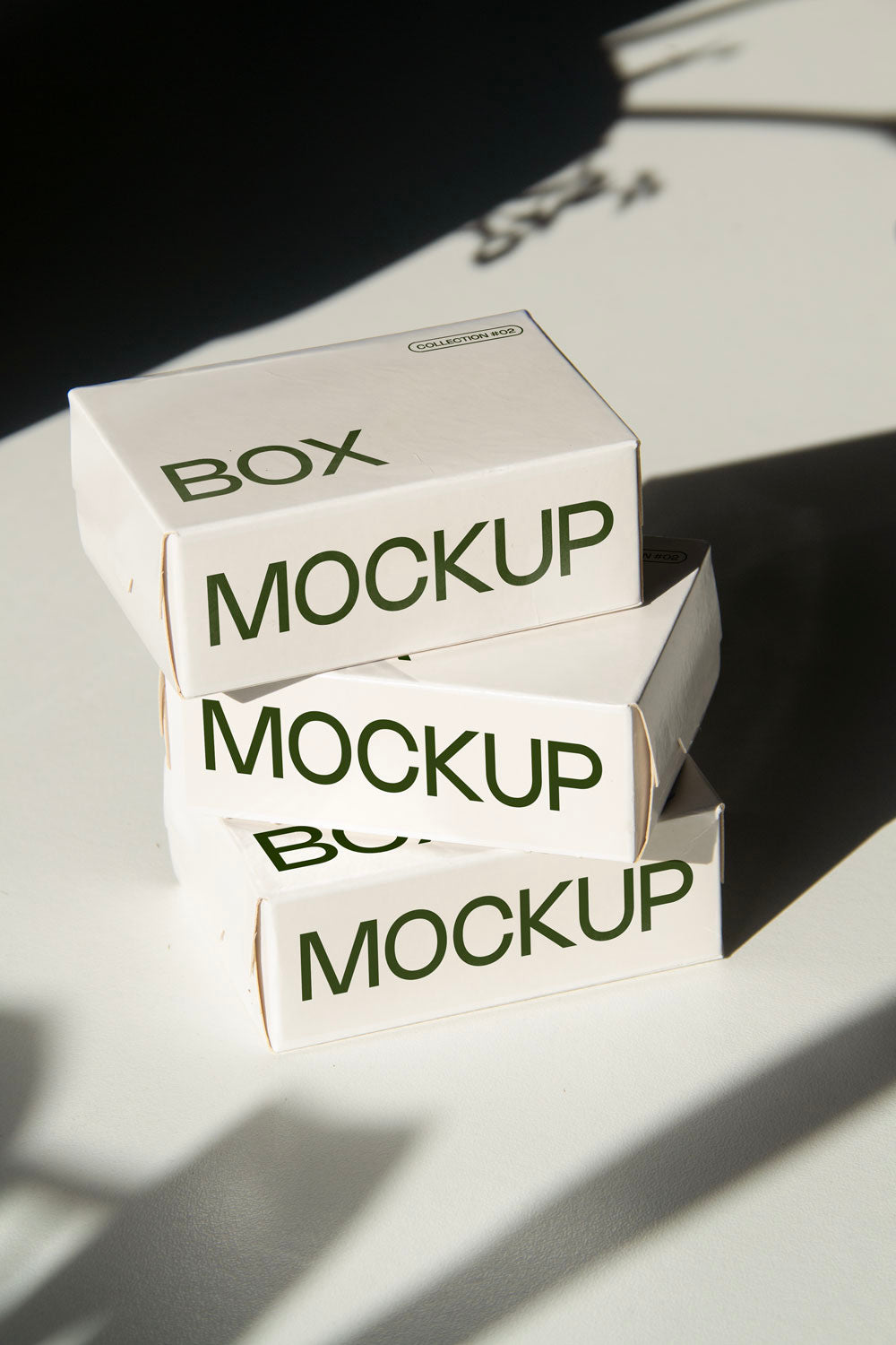 box packaging mockup PSD with three stacked paper boxes on sunlit desk and plant shadows