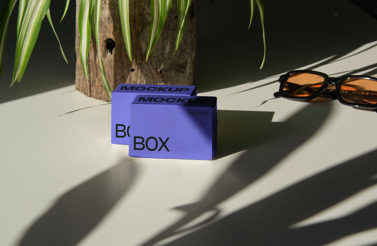 box packaging mockup PSD with three stacked paper boxes on sunlit desk and plant shadows