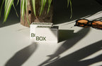 box packaging mockup PSD with three stacked paper boxes on sunlit desk and plant shadows