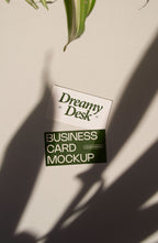business card mockup PSD with two cards (portrait and landscape) on sunlit desk with plant shadows