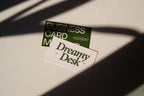 business card mockup PSD with two cards (portrait and landscape) on sunlit desk with plant shadows