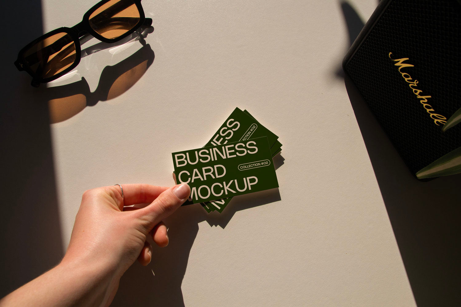 business card mockup PSD with two cards (portrait and landscape) on sunlit desk with plant shadows