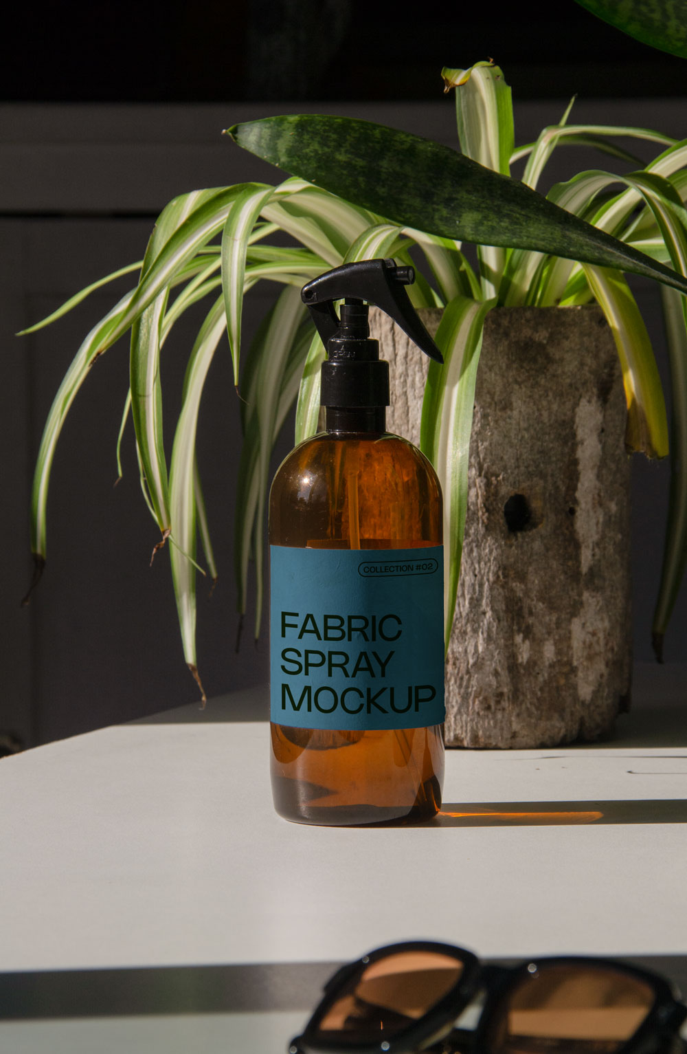 fabric spray bottle label mockup PSD on sunlit table with plant shadows and amber glass
