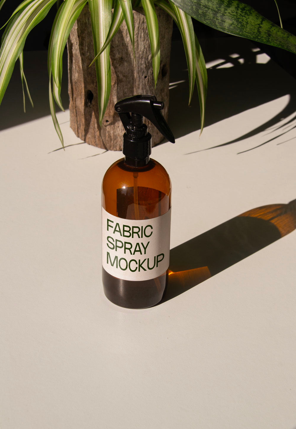 fabric spray bottle label mockup PSD on sunlit table with plant shadows and amber glass