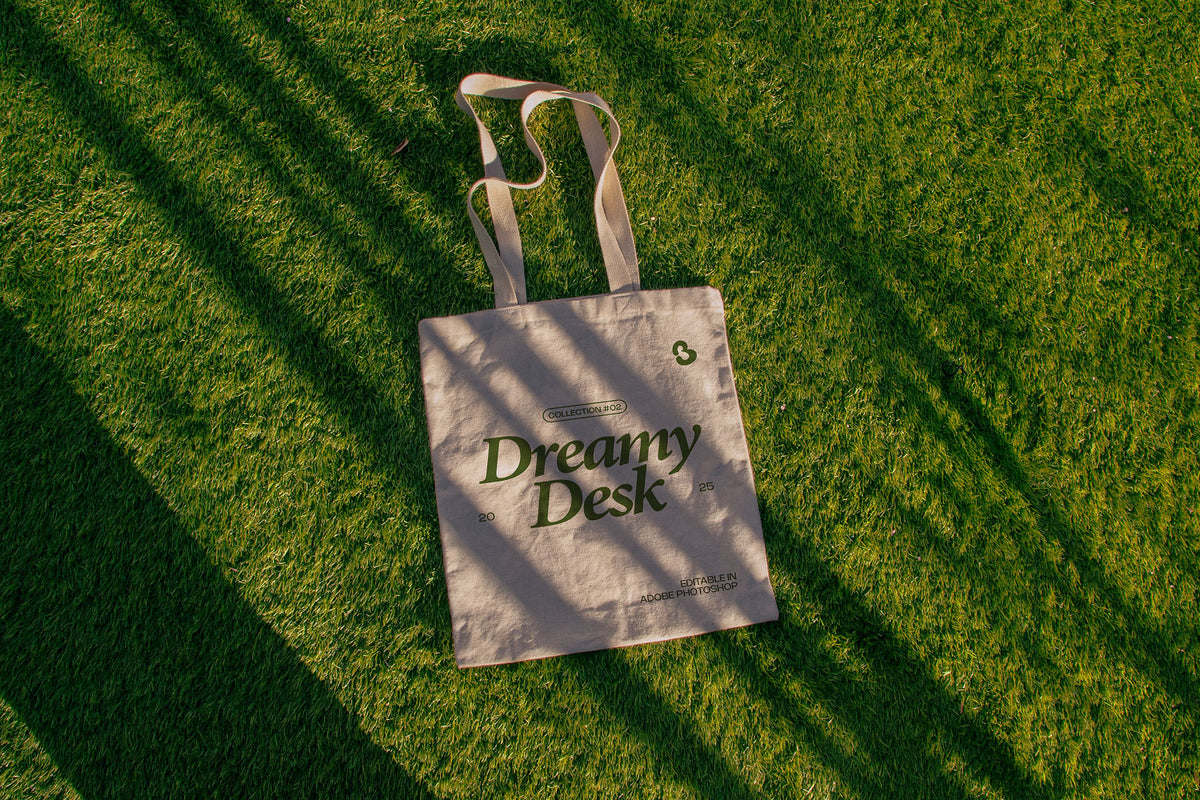 tote bag mockup PSD on sunlit grass with natural shadows and visible fabric texture