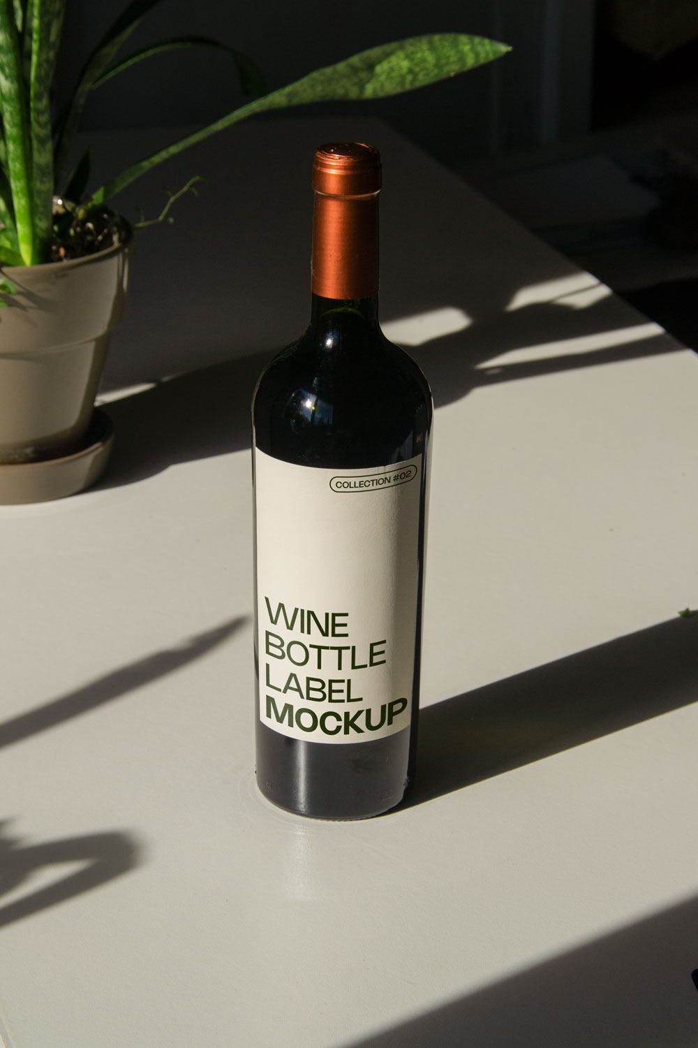 wine bottle label mockup PSD on sunlit table with plant shadows and glass reflections
