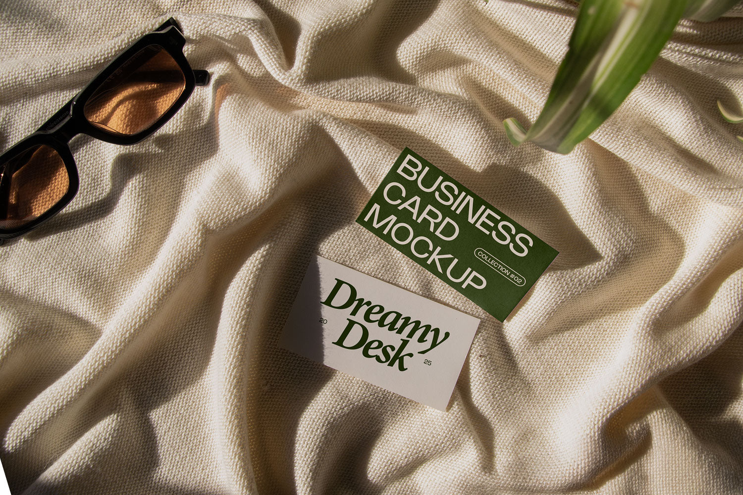 business card mockup PSD with two cards (portrait and landscape) on sunlit desk with plant shadows