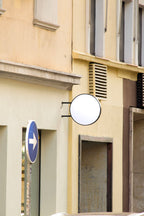 round storefront logo sign mockup PSD mounted on city building façade